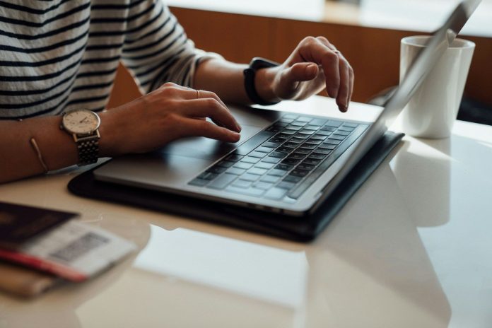 Photo by Etienne Boulanger person seated at the table using laptop